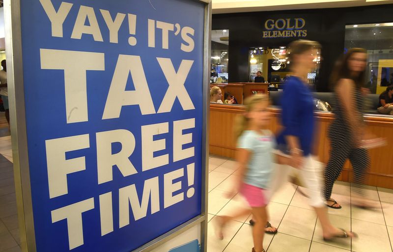 Customers pass by signs at Opry Mills Mall advertising Tax-Free weekend sales during the Tennessee sales tax holiday on July 29, 2016.