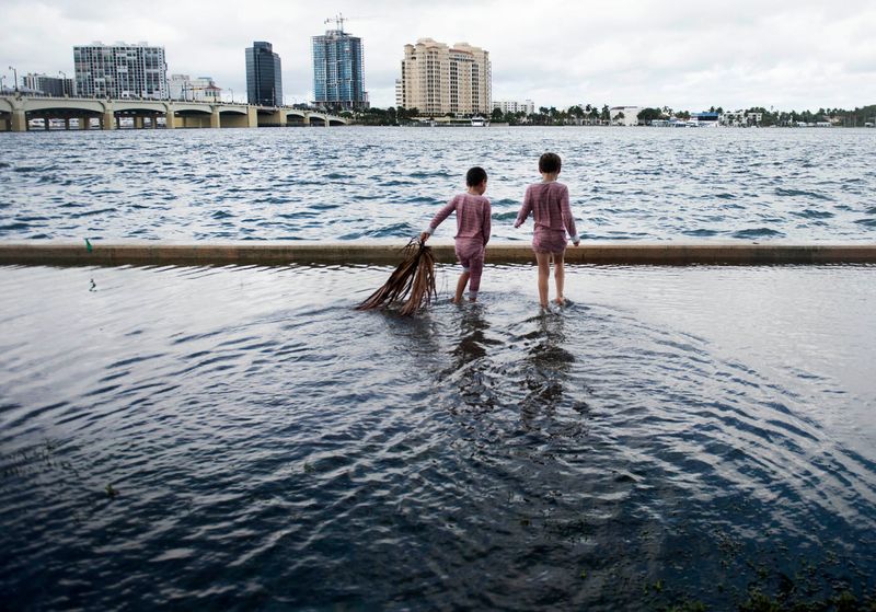Charlie, 5, and Jack Coleman, 7, of Palm Beach  look for crabs on a flooded Lake Trail near the Tidal Garden at Bradley Park November 10, 2022 in Palm Beach. Palm Beach escaped significant damage from Hurricane Nicole as it made on Hutchinson Island a 3 a.m. today.
