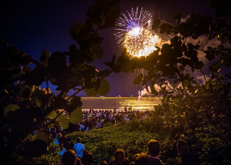 People watch the fireworks display from the boardwalk and the beach during the New Years Eve fireworks at the Naples Pier on Dec. 31, 2017.