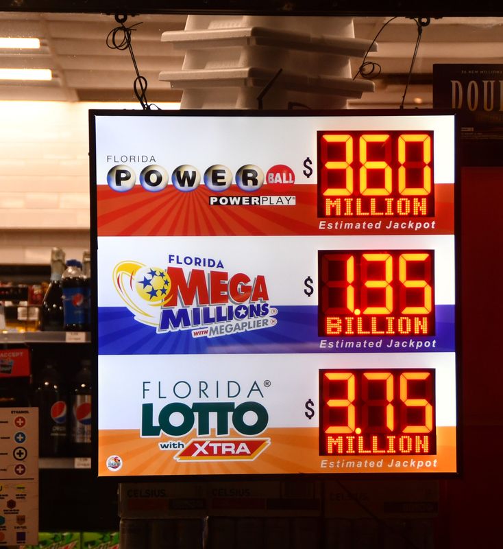 The sign in the winow of a Cocoa Beah 7-11 store shows the totals for the Mega Millions and the Powerball. The Mega Millions is up to 1.35 billion and the Powerball is up to 360 million Wednesday evening.