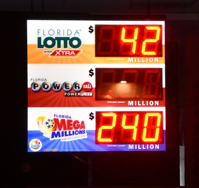 Signs in convenience stores show jackpot totals for Florida Lotto, Powerball and Mega Millions.