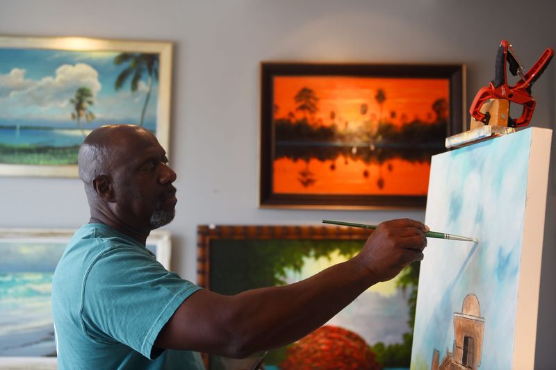 Ray McLendon works in a style known as Florida Highwaymen art, named after a group of black artists who painted vibrant Florida landscapes and sold their paintings up and down U.S. 1 from the 1950s to the 1980s. Photo taken July 2019.