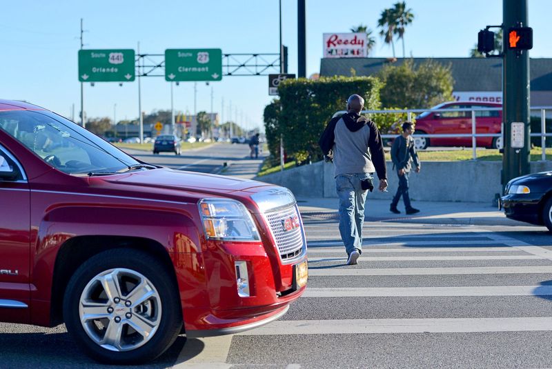 A pedestrian ignores the no crossing sign at a crosswalk near the U.S. Hwy 441/ 27 split on Tuesday, Jan. 24, 2017 in Leesburg, Fla. [AMBER RICCINTO / DAILY COMMERCIAL]