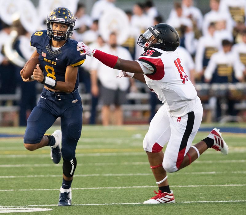 Naples quarterback Dominiq Ponder escapes the grasp of Amari Edgehill of Miami-Monsignor Pace during the game at Naples High Friday night, September 6, 2019.