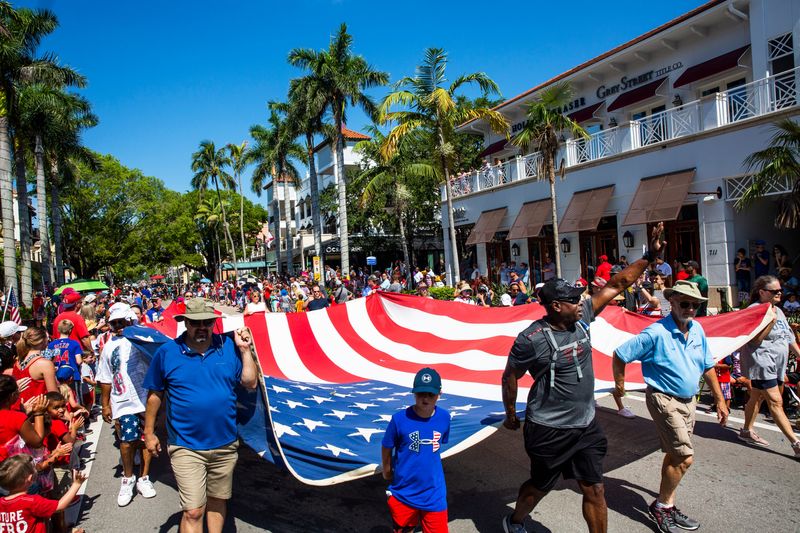 A giant American flag makes its way down Fifth Avenue South during the 4th of July Parade in downtown Naples, Florida, in 2018.