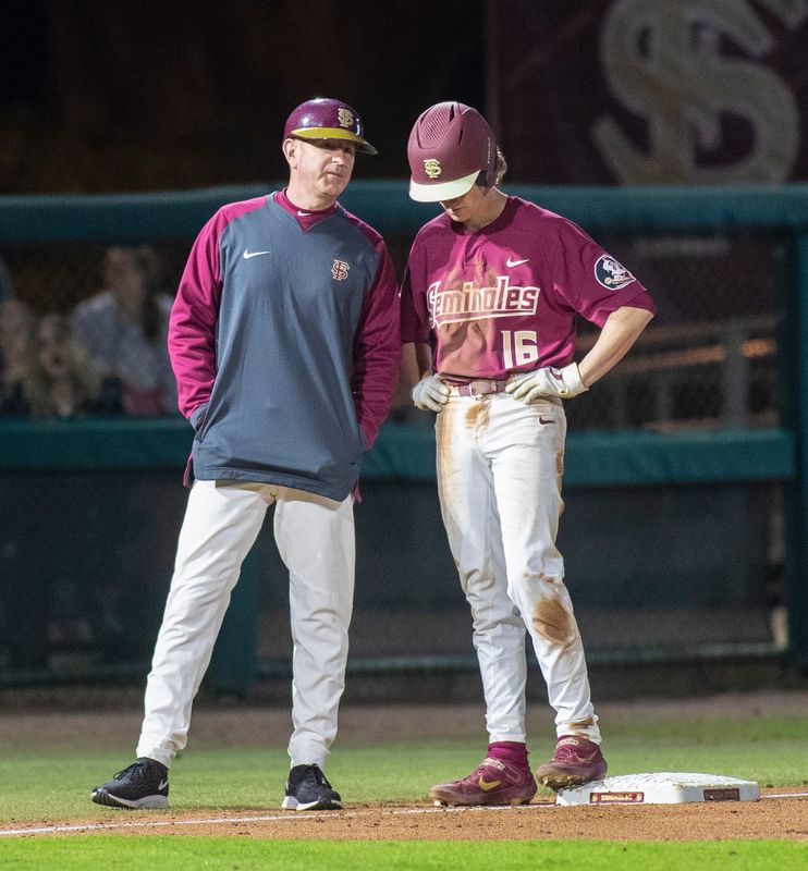 Florida State Seminoles head coach Mike Martin Jr. talks with Florida State Seminoles infielder Tyler Martin (16) while he's at third base.The Florida State Seminoles beat the Florida Atlantic Owls 5-1, Friday, Feb. 28, 2020.