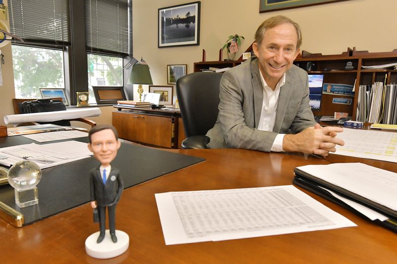 Duval County Supervisor of Elections Jerry Holland, shown in a file photo at a desk with one of several bobbleheads in his likeness, opted to file for re-election as elections supervisor rather than run for mayor in 2027.