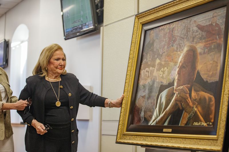Ann Bowden admires the portrait of her husband, Bobby Bowden, which was painted by Steve Skipper and was unveiled before the game Sunday, Sept. 5, 2021.