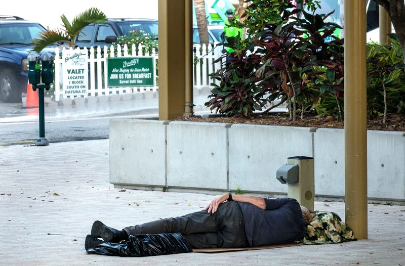 A man sleeps by the Great Lawn and Lake Pavilion in downtown West Palm Beach Tuesday morning, July 16, 2019.
