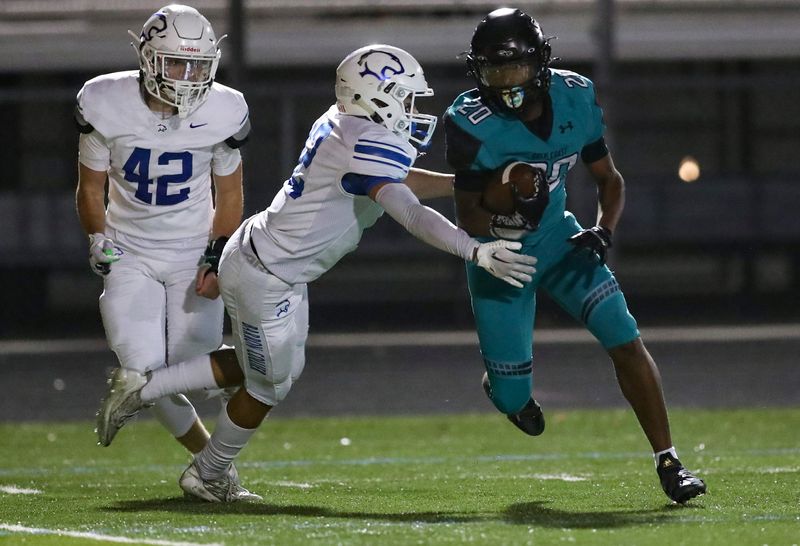 Gulf Coast Sharks running back Javien Altine (20) runs the ball down the field during the fourth quarter of the Catfish Bowl against the Barron Collier Cougars at Gulf Coast High School in Naples on Friday, Nov. 3, 2023.