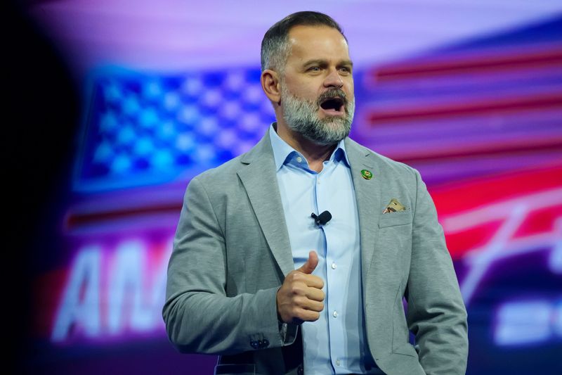 U.S. Rep. Cory Mills, shown speaking in Phoenix in 2023, has been questioned about his military service and claims he heroically saved several people during a 2003 Army tour in Iraq.