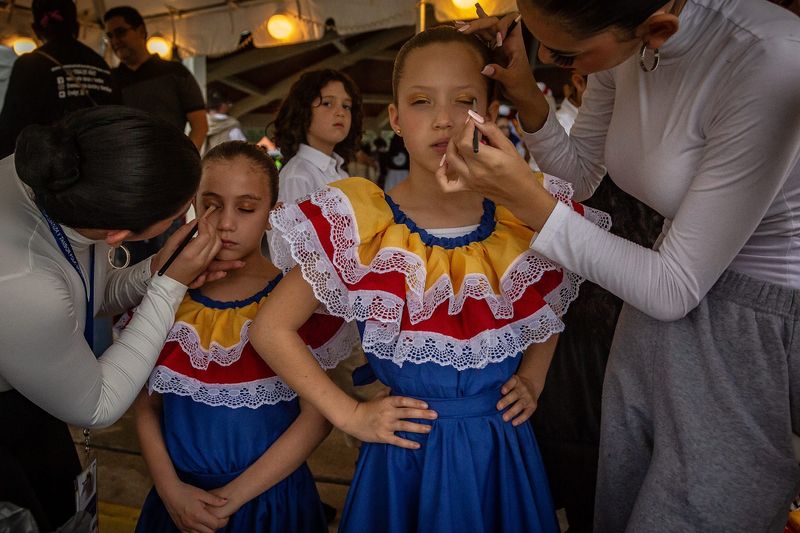 Left to right: Claudia Castillo, Coral Springs, Lucia Alemany, Weston, Sienna Reyes, Davie and Megan Lara, Coral Springs, finish makeup before a dance performance at the Fiesta de Pueblo celebration at Samuel J. Ferreri Community Park in Greenacres, Fla. on January 6, 2024.