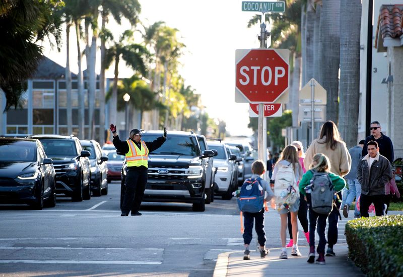 Palm Beach parking supervisor Loretta Brown directs traffic before school at Cocoanut Row and Seaview Avenue January 30, 2024 in Palm Beach.