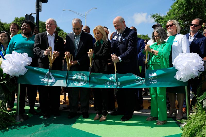 From left with scissors, U.S. Rep. John Rutherford, Jacksonville City Council President Ron Salem, Mayor Donna Deegan, President and CEO of Baptist Health Michael Mayo, and Groundwork Jacksonville CEO Kay Ehas, use oversized scissors to cut a ribbon during a ceremony Monday, May 6, 2024 outside the Prime Osborn Convention Center in Jacksonville, Fla. City officials, Groundwork Jacksonville and sponsors Baptist Health formally opened and celebrated the Emerald Trail LaVilla Link.