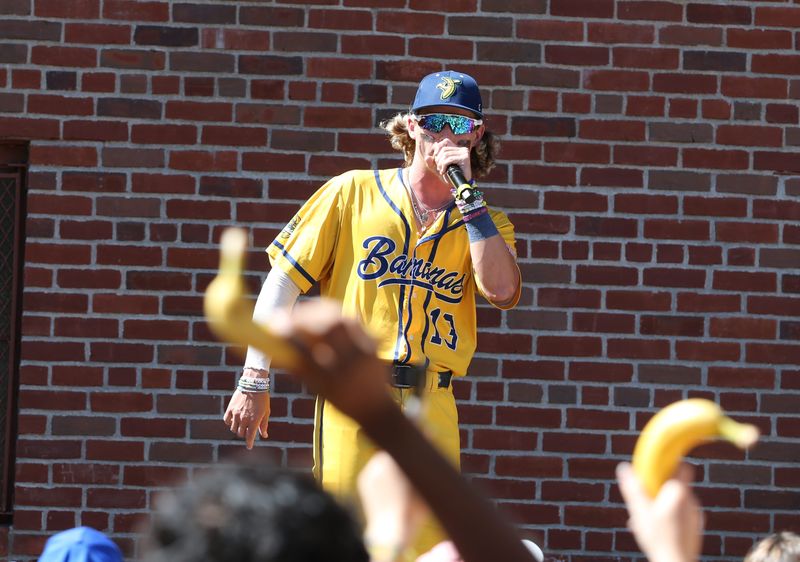 Fans hold up bananas as Dalton Mauldin sings during a pre-show outside Fenway Park. Lake City native Mauldin, who has since moved from the Savannah Bananas to the Loco Beach Coconuts, will be among the Banana Ball players at VyStar Ballpark from July 2-4.