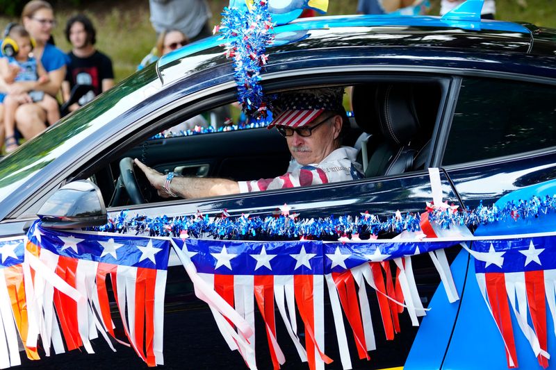 Ron Semmler drives a car decorated in patriotic colors along the Ridgefield Park Fourth of July Parade route,Thursday, July 4, 2024.