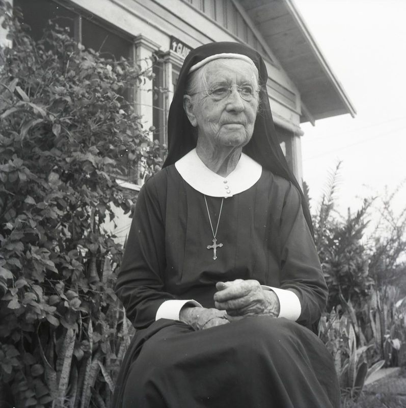 Circa 1955, Deaconess Harriet Bedell sitting in front of the Glade Cross Mission.