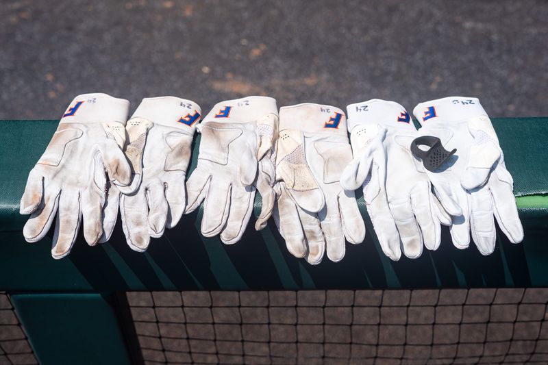 Jun 17, 2024; Omaha, NE, USA; Gloves for Florida Gators outfielder Blake Brookins (24) sit in the dugout before the game against the NC State Wolfpack at Charles Schwab Field Omaha. Mandatory Credit: Dylan Widger-USA TODAY Sports