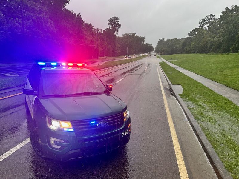 An Alachua County Sheriff's Office vehicle blocks a portion of West Newberry Road that was flooded from rains from Hurricane Debby near Westside Baptist Church.