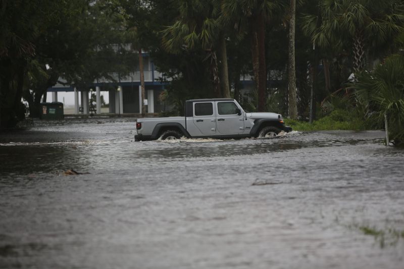 Cars drive through washed out streets in Steinhatchee, Florida, where Hurricane Debby made landfall, Aug. 5, 2024.