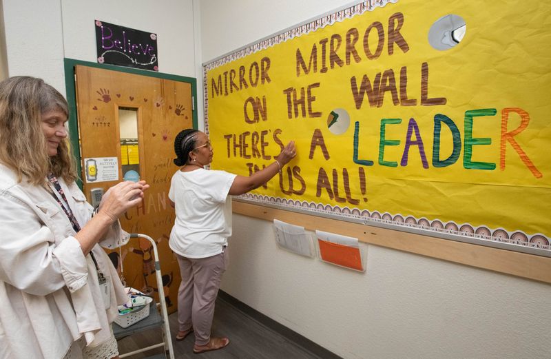 Pre-K teachers Gabrielle Merritt, left, and Tiana Walker create an inspirational message in between their classrooms for the start of the upcoming school year at C.A. Weis Elementary School in Pensacola on Tuesday, Aug. 6, 2024.
