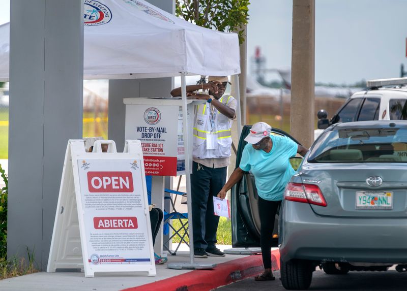 A voter prepares to deliver her ballot at a Vote-by-Mail drop off box outside the new Palm Beach County Supervisor of Elections building at 4301 Cherry Road on August 7, 2024 in West Palm Beach, Florida.
