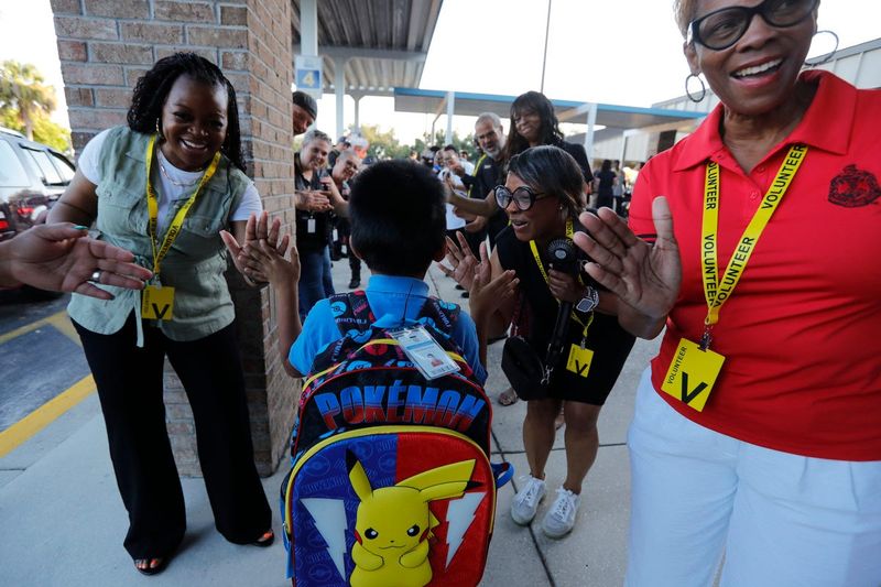 Elementary student Pedro Miguel, salutes greeters on his way to class at James Stephens Elementary School in Fort Myers Monday morning, August 12, 2024, during the event known as the GentlemanÕs Welcome.