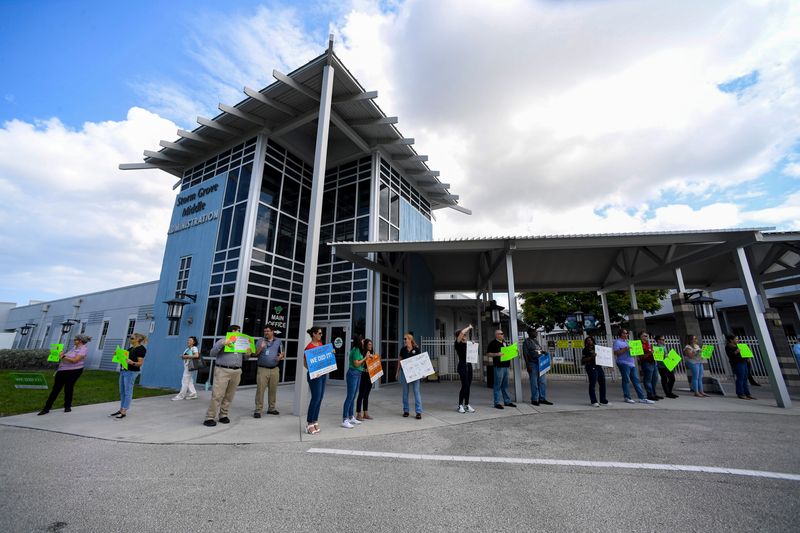 The School District of Indian River County employees wave hand-made signs with words of encouragement for students and teachers celebrating the end of the first week of school, Friday, Aug. 16, 2024, at Storm Grove Middle School’s parent pick-up loop at 6400 57th St.