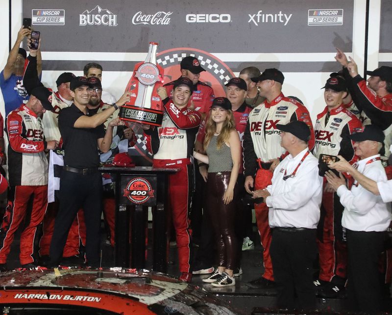 Harrison Burton lifts his trophy in Victory Lane, Saturday August 24, 2024 after winning the Coke Zero Sugar 400 at Daytona International Speedway.