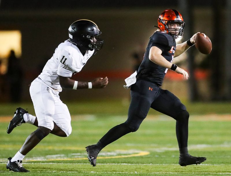 Lely Trojans quarterback Carter Quinn (8) looks for an open receiver as Golden Gate Titans linebacker Lasner Nord (11) pursues him during the third quarter of a game at Lely High School in Naples on Friday, Aug. 30, 2024.