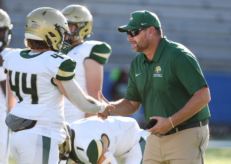 Fleming Island head coach Derek Chipoletti shakes hands with Fleming Island's Jayden Smith (44) during warm ups before a 2024 game at Riverside.