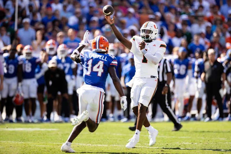 Aug 31, 2024; Gainesville, Florida, USA; Miami Hurricanes quarterback Cam Ward (1) throws the ball under pressure from Florida Gators defensive back Jordan Castell (14) during the first half at Ben Hill Griffin Stadium. Mandatory Credit: Matt Pendleton-USA TODAY Sports