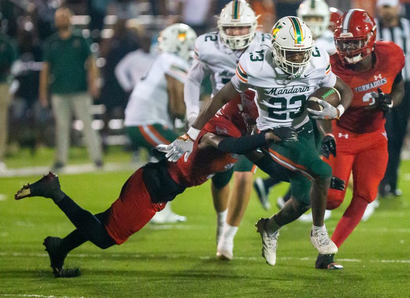 Mandarin Mustangs running back Shaunqueze Foster (23) drags a player in the first half. The Bradford Tornadoes hosted the Mandarin Mustangs at David Hurse Stadium at Bradford High School in Starke, FL on Friday, September 13, 2024. The Mustangs lead 13-6 at the beginning of the fourth quarter.[Doug Engle/Ocala Star Banner]