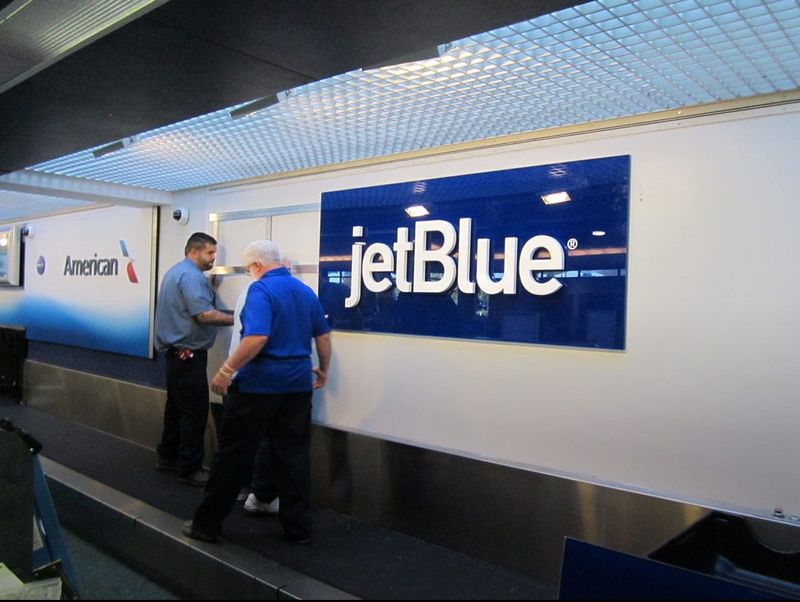 Workers at Daytona Beach International Airport in 2015 install a sign for JetBlue in the baggage check-in area in anticipation of the low-cost carrier's launch of daily nonstop flights to New York's John F. Kennedy International Airport in January 2016. JetBlue ended that service exactly three years later.