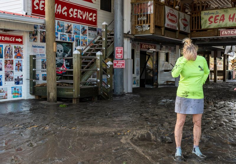 Sea Hag owner Danielle Norwood stands at her business that was damaged after Hurricane Helene hit the area on September 27, 2024 in Steinhatchee, Florida.