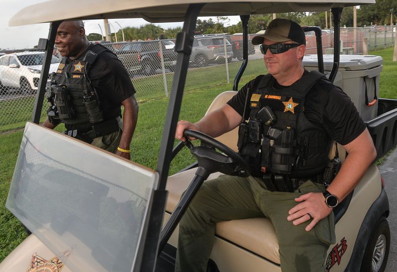 Indian River County Sheriff's Office School Resource Deputies Michael Snowhill (right) and Darrell Rivers keep watch as parents and students arrive at the visitors' entrance at the Vero Beach High School Citrus Bowl for the school's game against Fort Pierce Central High School on Friday, Sept. 27, 2024.