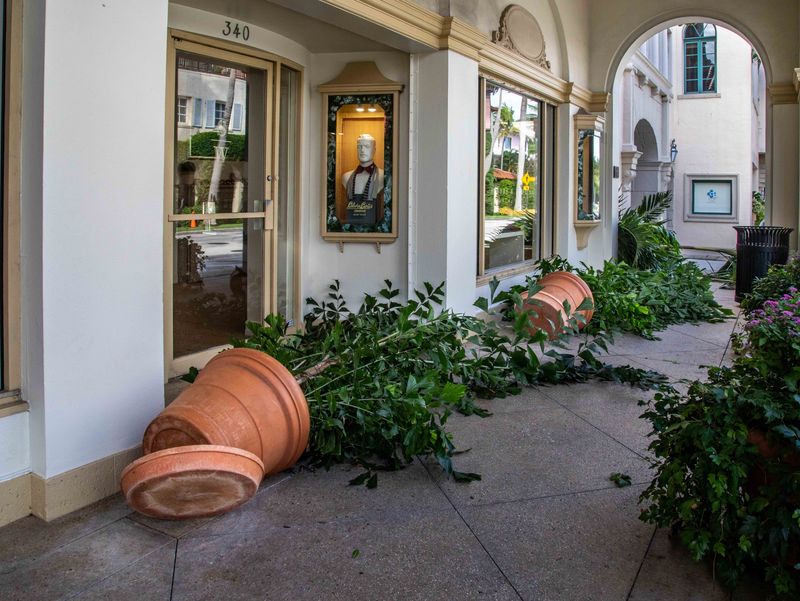 Large planters lay on their side in front of Stubbs and Wootton on Worth Avenue Oct. 10, 2024 after winds from Hurricane Milton passed through the area.