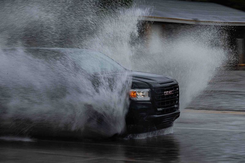 Morning traffic navigates floodwaters at Crestwood Boulevard and Dixie Highway as heavy rains from storm bands from former Hurricane Milton passed over Lake Worth Beach, Fla., on October 11, 2024.