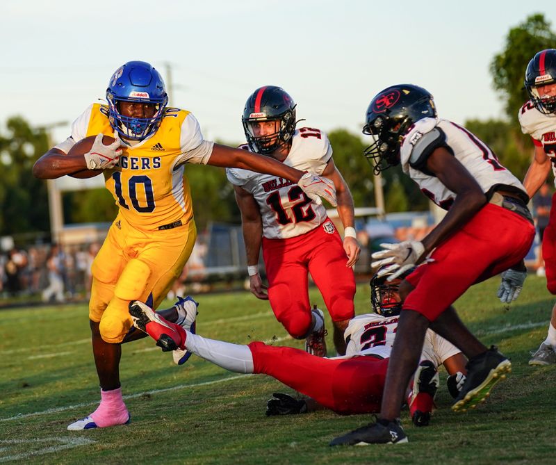 Martin County running back Paul Hendrix is pursued by South Fork's Maddox Weiner (12) and a host of Bulldogs during the 41st edition of the Martin Bowl on Monday, October 14, 2024 in Stuart. The Tigers won 35-25.
