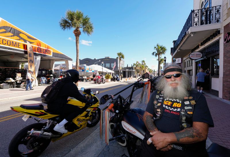 Sam Acquaro of Port Orange, a Biketoberfest regular for decades, watches the happenings on Main Street on opening day of Biketoberfest 2024 in Daytona Beach.