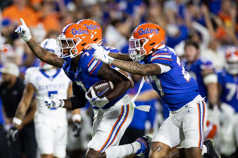 Oct 19, 2024; Gainesville, Florida, USA; Florida Gators defensive back Trikweze Bridges (7) and Florida Gators defensive back Dijon Johnson (27) celebrate an interception against the Kentucky Wildcats during the first half at Ben Hill Griffin Stadium. Mandatory Credit: Matt Pendleton-Imagn Images