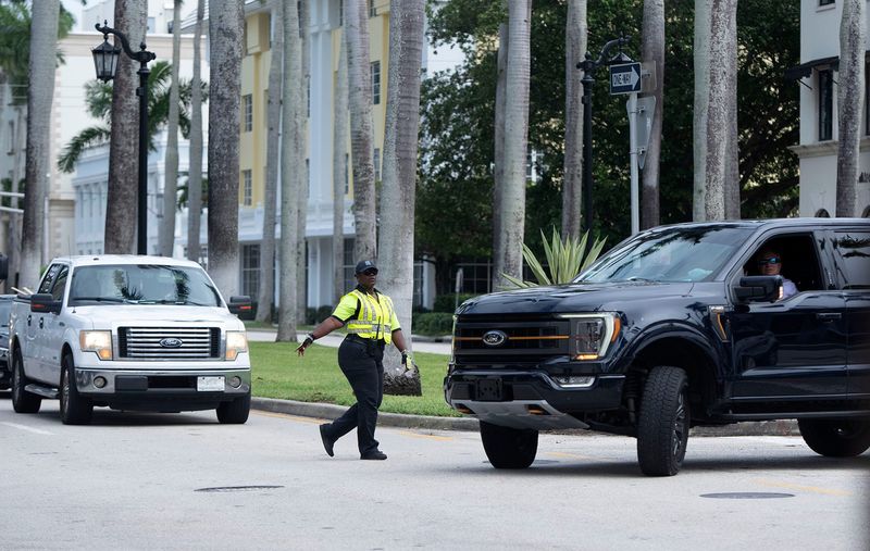 Palm Beach parking enforcement employee Abina Walkes directs traffic on Royal Palm Way as motorists sit in westbound traffic on the Royal Park Bridge on Oct. 23, 2024. Town officials issued an alert Tuesday urging motorists to consider using the Flagler Memorial Bridge due to heavy traffic on Royal Palm Way caused by a lane closure in West Palm Beach.