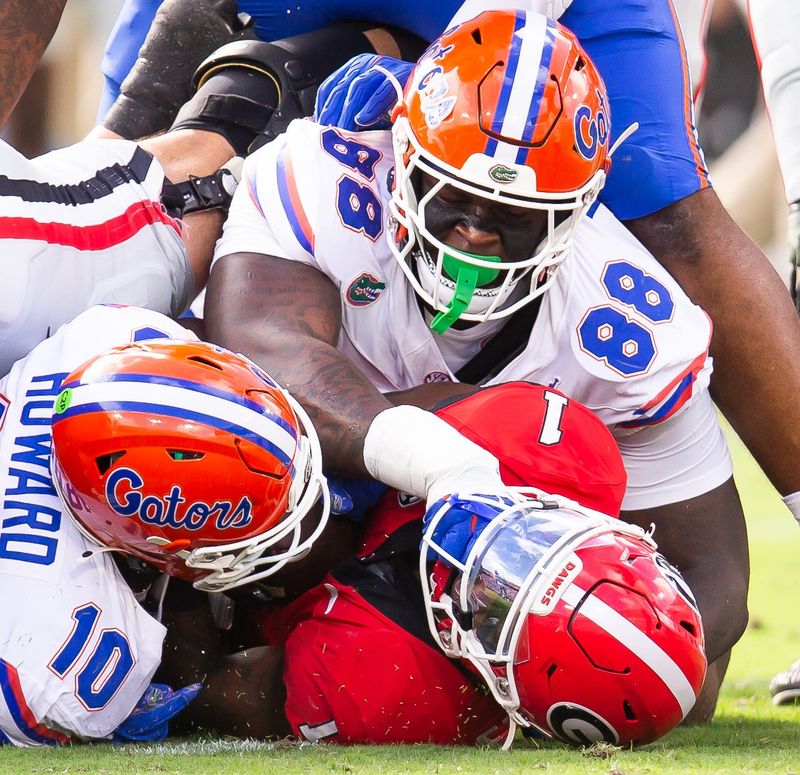 Florida Gators defensive lineman Caleb Banks (88) pushes Georgia Bulldogs running back Trevor Etienne (1) helmet to the ground during the first half at EverBank Stadium in Jacksonville, FL on Saturday, November 2, 2024. [Doug Engle/Gainesville Sun]