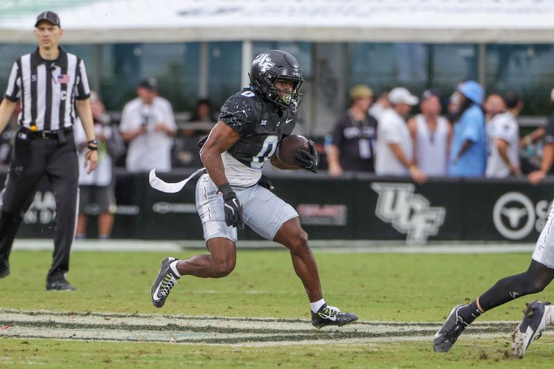 Nov 2, 2024; Orlando, Florida, USA; UCF Knights running back Johnny Richardson (0) runs the ball against the Arizona Wildcats during the second half at FBC Mortgage Stadium. Mandatory Credit: Mike Watters-Imagn Images