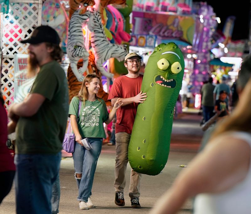Tyler Van Der Staay and Savannah Pizzo walk with their prize during opening night of the Volusia County Fair in DeLand, Thursday, Nov. 7, 2024.