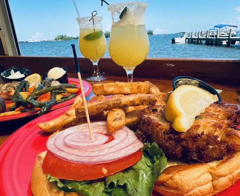 Crab cake sandwich and fries (salmon special in background) at Blackfins Riverfront Grill, Sebastian.