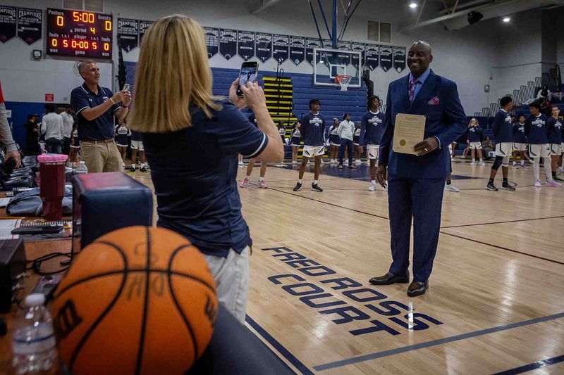 Head coach Fred Ross poses for photos before the William T. Dwyer High School Panthers hosted the Palm Beach Gardens Community High School Gators in Florida High School Athletic Association varsity boys basketball in Palm Beach Gardens, Fla., on November 19, 2024. The Dwyer gymnasium was named the Fred Ross Court honoring the school's longtime basketball coach in a ceremony before the game.