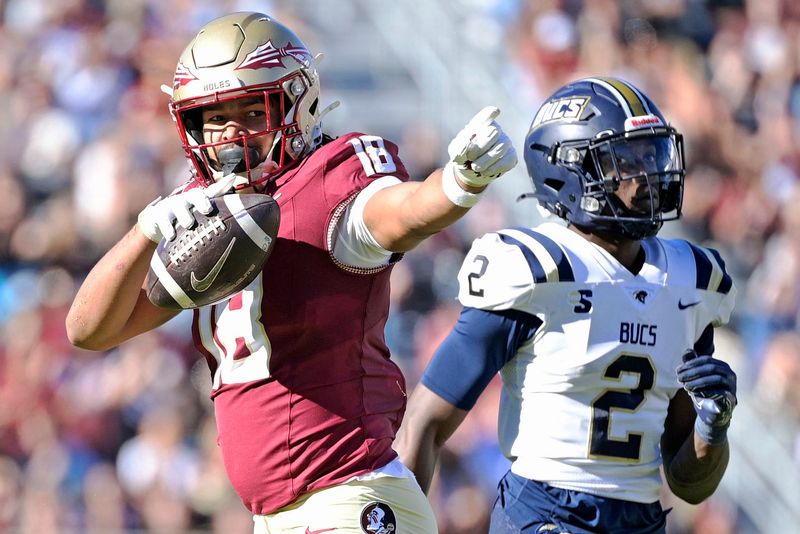 Nov 23, 2024; Tallahassee, Florida, USA; Florida State Seminoles tight end Landen Thomas (18) celebrates a first down grab as Charleston Southern Buccaneers safety Davion Williams (2) looks on during the second half of the game at Doak S. Campbell Stadium.