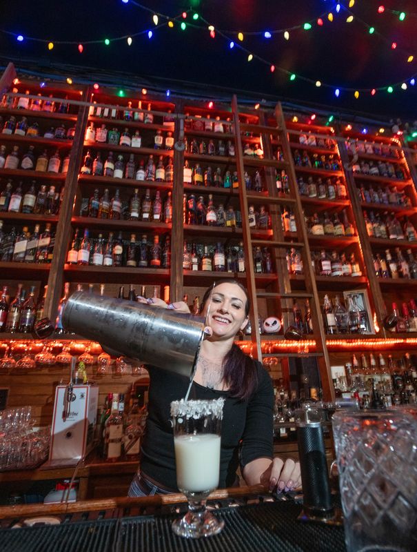 Bartender Jordin Matthews prepares a Wonderland cocktail at the Old Hickory Whiskey Bar which is decorated for the holidays with a Nightmare on Palafox theme in downtown Pensacola on Tuesday, Nov. 26, 2024.