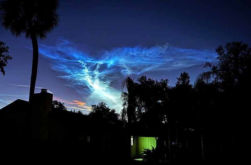 Noctilucent clouds glow a spectrum of colors, as they hang over a Ormond Beach neighborhoor, in the early morning light, Wednesday December 4, 2024 a result of rocket vapor trails from the pre-dawn Space X launch.